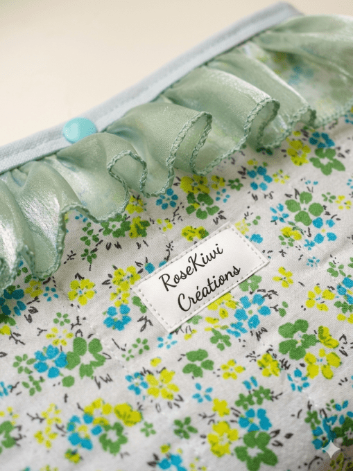 Pochette à livres molletonnée vert et bleu sur fond blanc